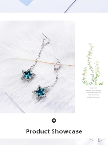 Detail of star-shaped drop earrings featuring blue crystals and shimmering accents