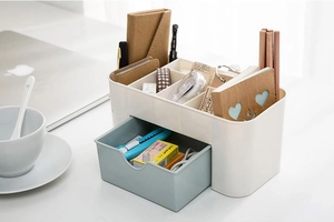 Detailed view of white plastic desk organizer with a light blue drawer for office stationery
