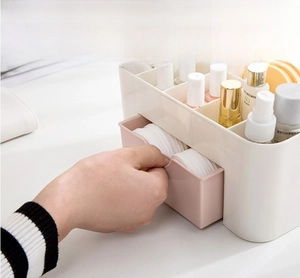 Detail of drawer makeup organizer showing a hand opening the pink cosmetic storage compartment