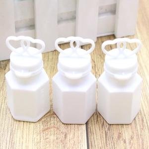 Three white heart-top bubble wand bottles on a rustic wooden table for wedding decor