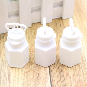 Detail of heart-shaped wand caps on white plastic wedding bubble tubes for event decor