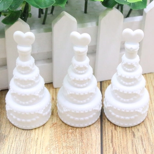 Detailed view of three white heart-topped cake shaped bubble wand bottles for weddings