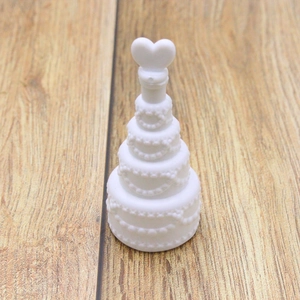 White multi-tier cake bubble bottle with heart cap on rustic wooden floor background