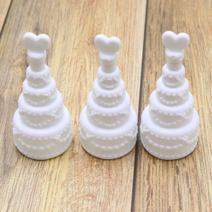 Three white heart-top bubble wand bottles arranged on a wooden background for weddings