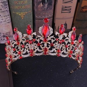 Close-up of golden baroque crown with red crystals and clear rhinestones on antique books