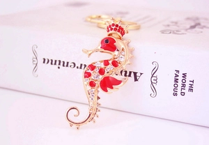 Close-up of golden seahorse keychain with red enamel and sparkling crystal rhinestones