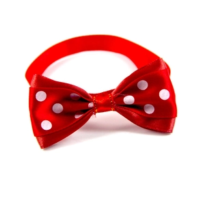 Detail of red Christmas pet bowtie with white polka dots on premium satin fabric