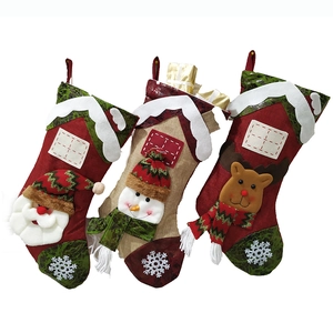 Three assorted Christmas stockings with Santa, Snowman and Reindeer designs on white backdrop