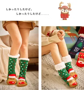 Close-up of green Christmas fleece socks with reindeer patterns and non-slip soles