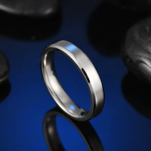 Close-up of 4mm polished stainless steel ring showing smooth beveled edges on blue base