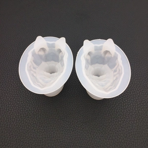 Detailed view of two geometric wolf head silicone molds on a black textured background
