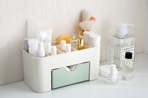 Detail view of multi-compartment cosmetic organizer with drawer and split-color design