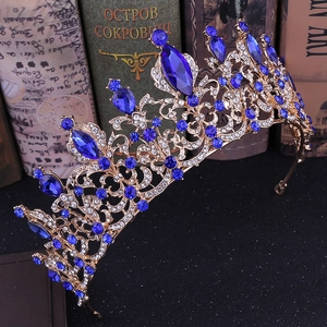 Detailed close-up of Baroque gold crown featuring deep blue gems and sparkling rhinestones