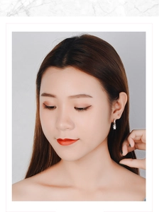 Close-up of a silver star drop earring worn by a model in a minimalist style