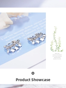 Close-up of silver star drop earrings with polished finish on artistic background