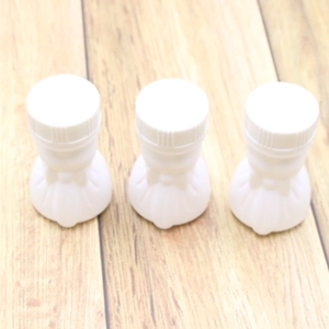 Three white wedding bubble empty bottles in dress shape on a rustic wooden background