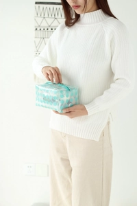 Detailed view of large transparent PVC makeup bag with light blue polka dots and zipper