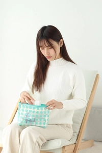 Blue wave point makeup bag in clear PVC shown with model during daily use