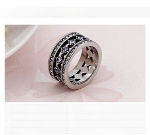 Macro shot of stainless steel ring with geometric cut-outs and white zircon inlay