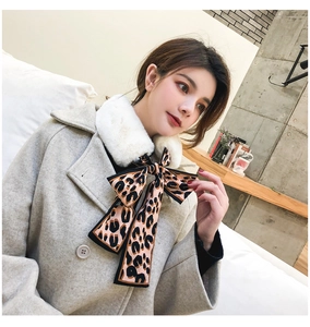 Close-up of a white faux fur collar scarf with a leopard print silk bow detail