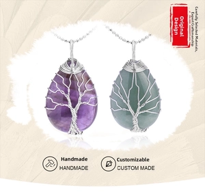 Detailed close-up of handmade wire-wrapped tree of life crystal teardrop pendant