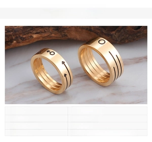 Detail of 18K gold-plated titanium rings showing engraved male and female gender symbols