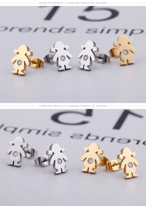 Macro shot of gold and silver girl silhouette stud earrings with sparkling crystals