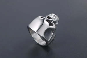 Macro detail of polished stainless steel skull ring with intricate punk engraving