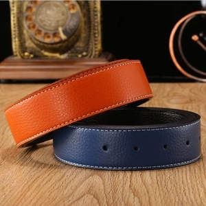 Detail view of lychee texture leather belts with white stitching in orange and blue