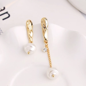 Detail of asymmetric pearl earrings with gold wrinkled metal and crystal accents