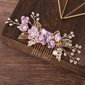 Detailed view of handmade gold bridal hair comb with purple flowers and white pearls