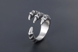 Detailed close-up of retro dragon claw ring with vintage textured scales on gray background
