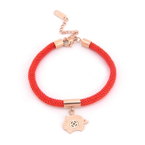 Detail of red braided rope bracelet with rose gold pig charm and lobster clasp closure