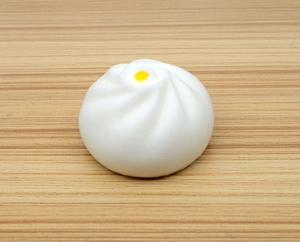 Détail de la texture mate et des plis réalistes du jouet squishy en forme de pain blanc