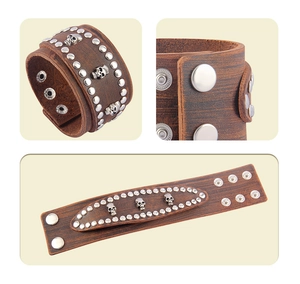 Detail view of brown leather skull bracelet with metallic studs and snap button closure