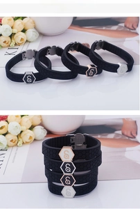 Detail view of black silicone sports bracelet with honeycomb texture and metal hexagon buckle