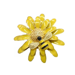 Detail of yellow daisy flower brooch with small bee in colorful enamel and polished metal