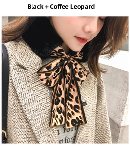 Detail of faux fur collar with brown leopard print satin ribbon tied in a bow