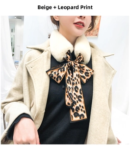 Detail of faux rabbit fur scarf with leopard print silk ribbon tied in a bow