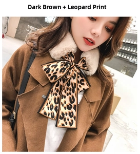 Detail of leopard print silk bow and beige faux rabbit fur collar on a dark coat