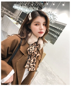 Detail of leopard print silk ribbon scarf paired with caramel coat and faux fur collar