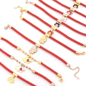 Détail de cordes tressées rouges et de breloques cochon en or et or rose poli