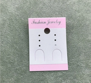 Detail view of pink and white cardboard jewelry display card with Fashion Jewelry text