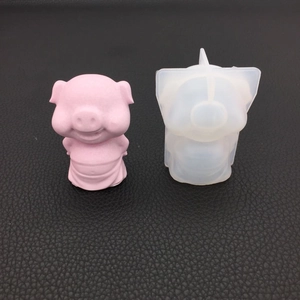 3D pig resin mold with finished pink piglet figurine on black leather background