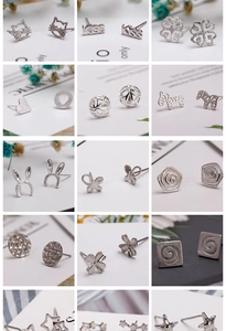 Macro detail of various 925 silver stud earrings in heart, star, and animal shapes