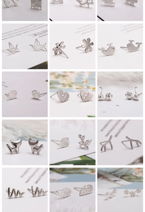Close-up of assorted silver stud earrings with nature themes like leaves and animals