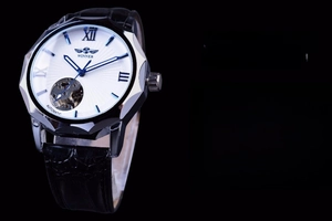 Macro view of white skeleton dial with blue Roman numerals and stainless steel bezel
