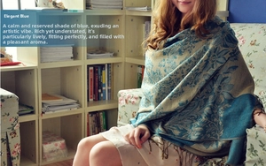 Detail of elegant blue bohemian floral jacquard shawl with decorative long tassels