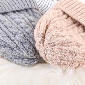Detailed macro view of gray and beige mohair knit hats with classic cable patterns