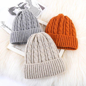 Detailed knit texture of mohair beanies in grey, beige and orange for winter warmth